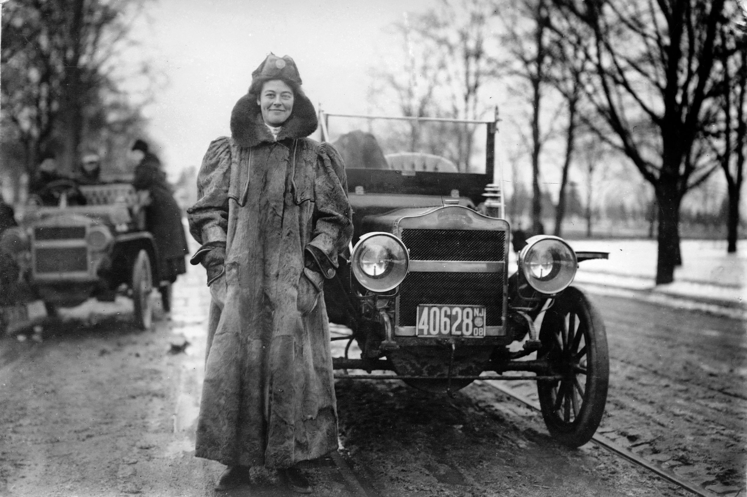 woman standing by a Maxwell Motors car